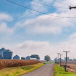Rural road farm Wisconsin grain bins electric power lines corn field