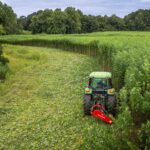 aerial view of tractor harvesting hemp fields